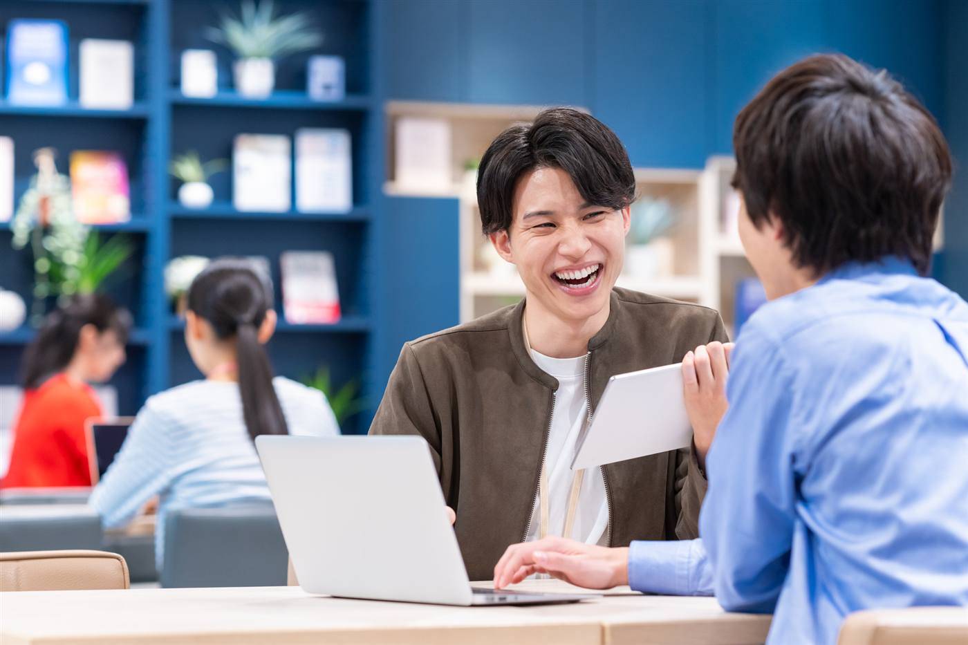 タブレットを見せながら、笑顔で会話するバディとクライアントの様子