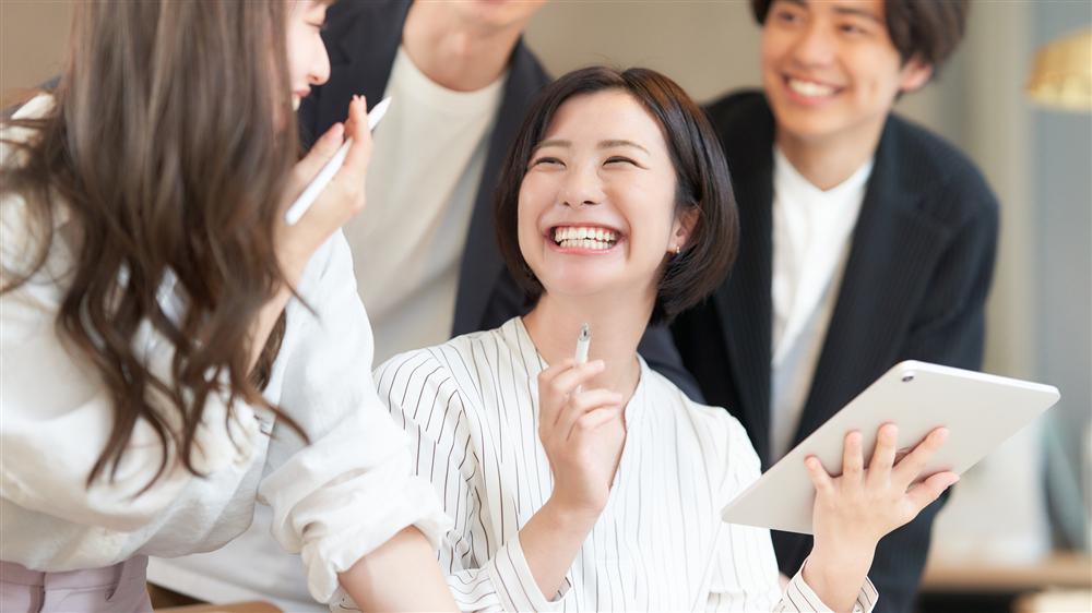 タブレットを囲み、笑い合いながら話すバディとクライアントの様子